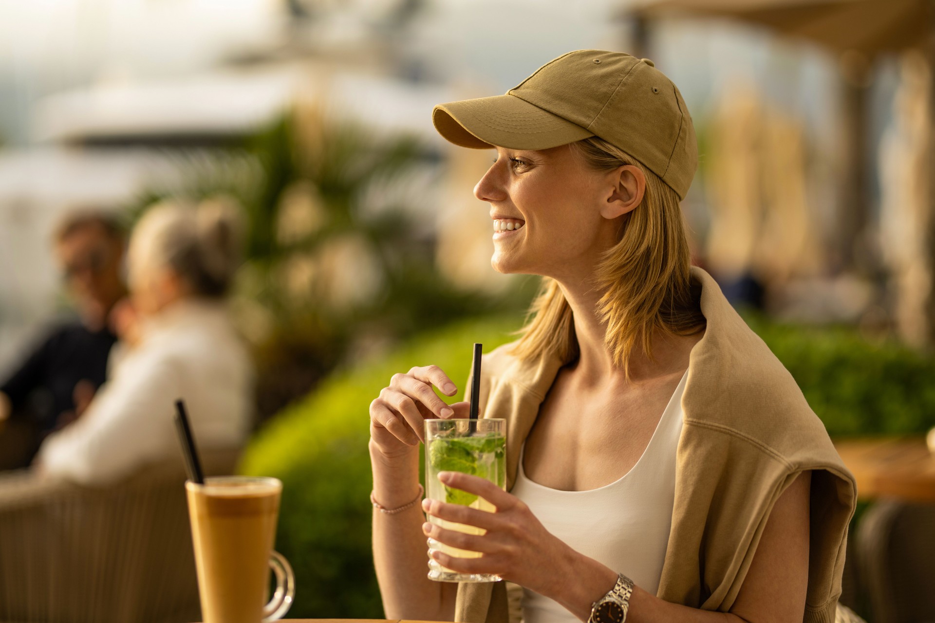 Young woman enjoying herself in street cafe at sea resort